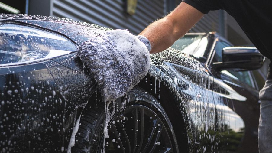 Fahrzeug wird bei HL Autopflege von Hand mit Schaum gewaschen